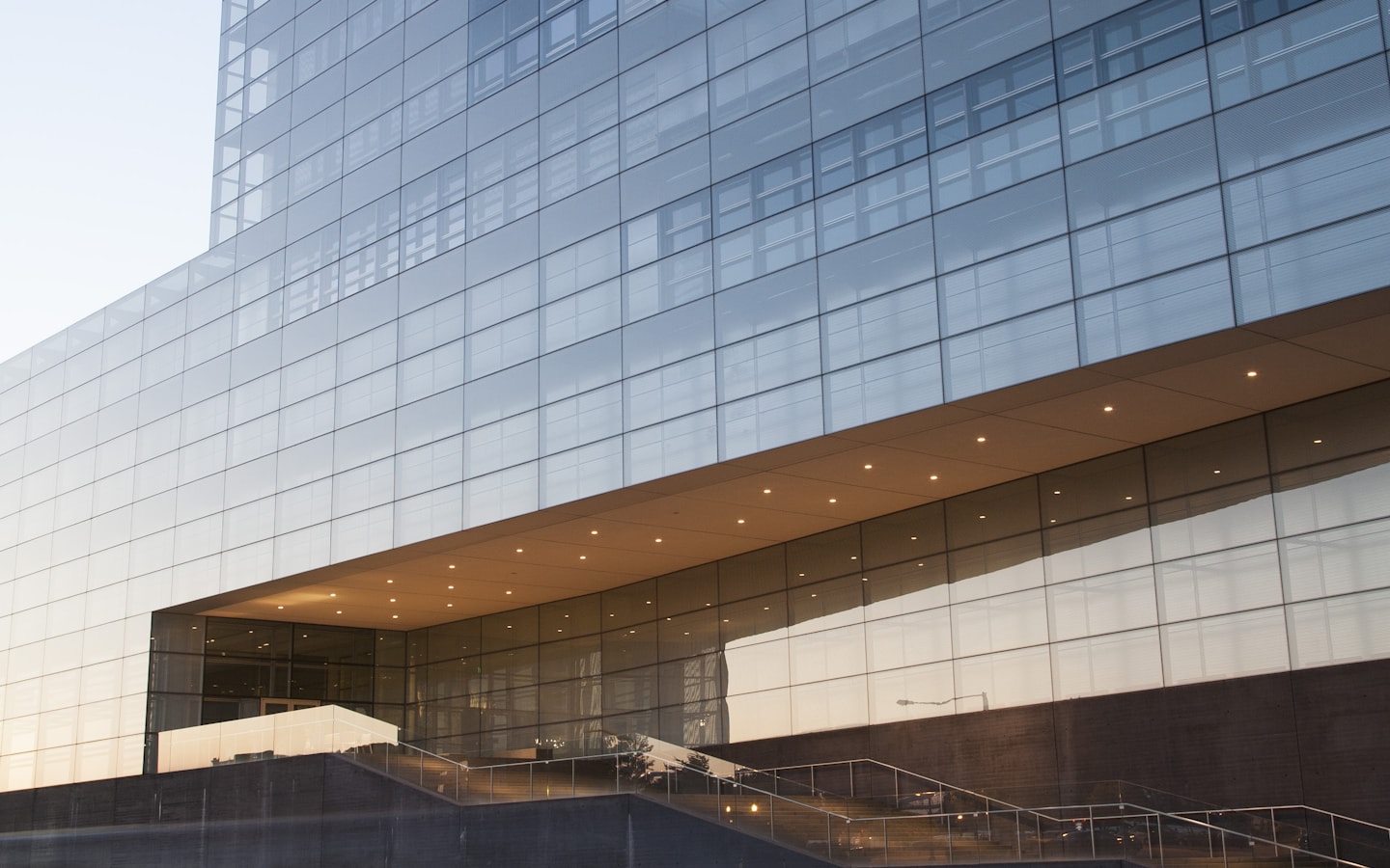 A modern glass-facade commercial office building at dusk