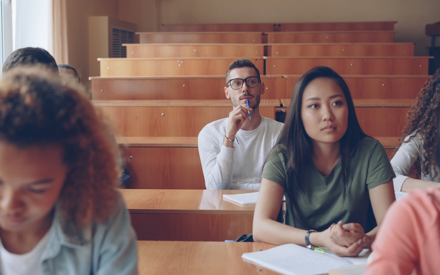 Students seated in a university lecture hall taking notes