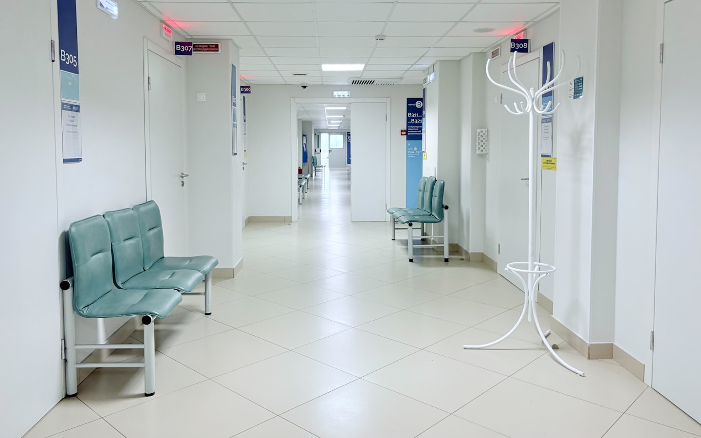 A clean, quiet hospital corridor with seating along one wall