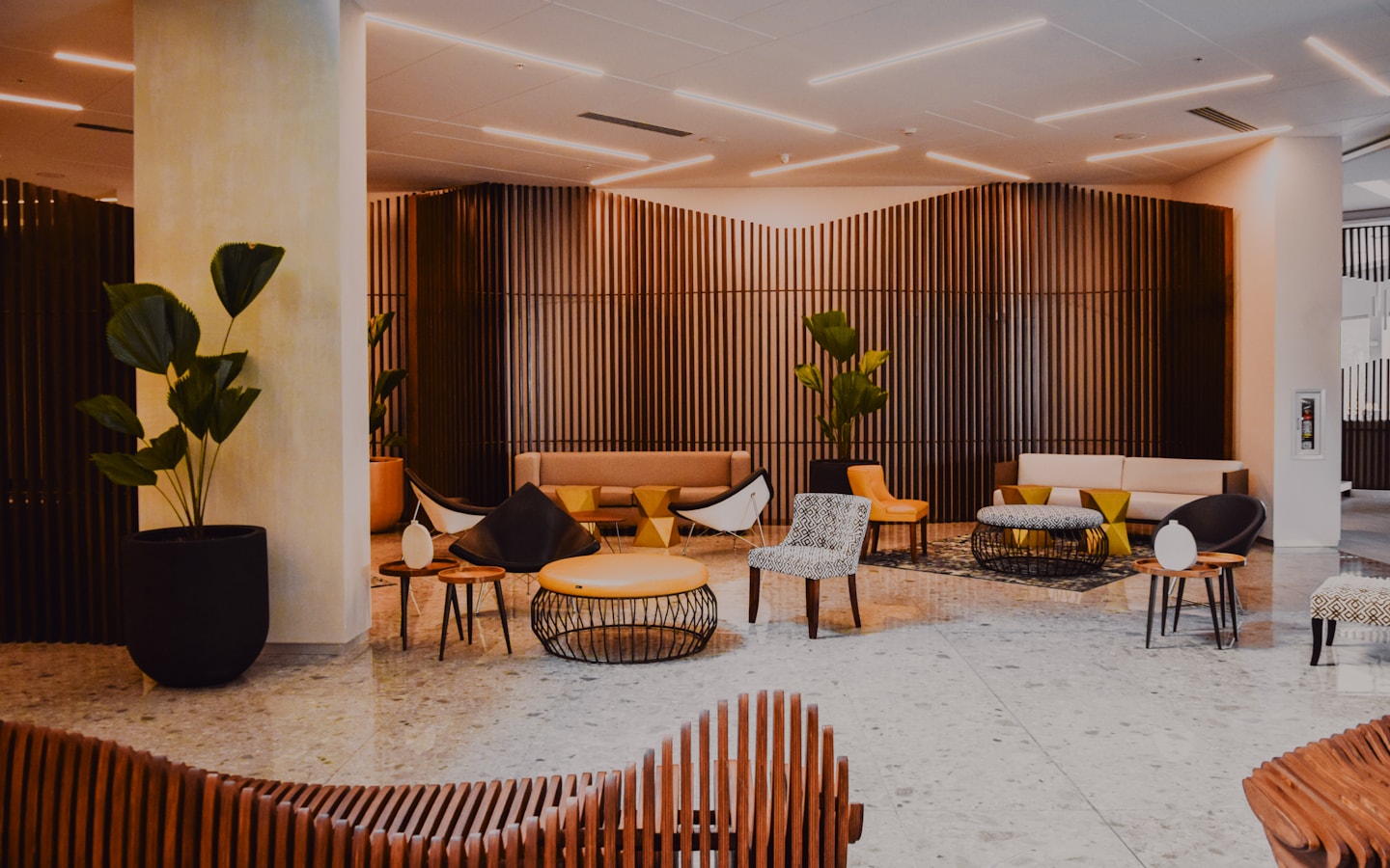 A contemporary hotel lobby with designer seating and timber wall panelling